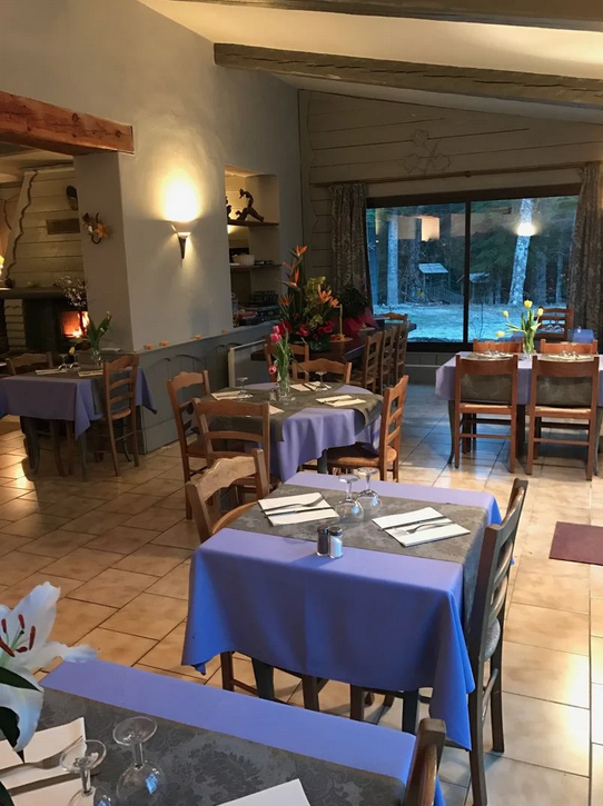 Salle de restaurant avec cheminée à l'auberge de la forêt Thorenc Station